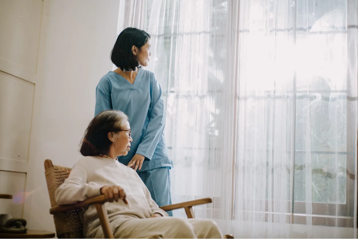 Caregiver and senior resident in warm sunlit room