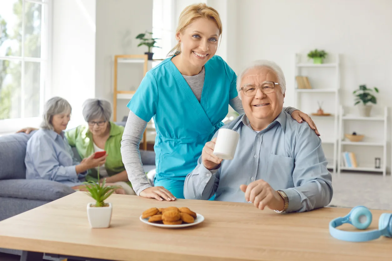 Caregiver sharing a warm moment with senior resident at dining table